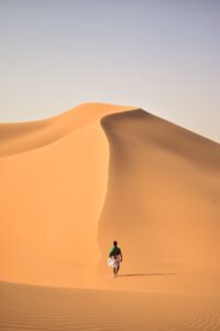a person walking in the middle of the hot desert
