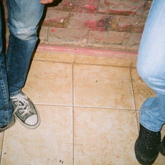 two person wearing blue jeans and lace up shoes