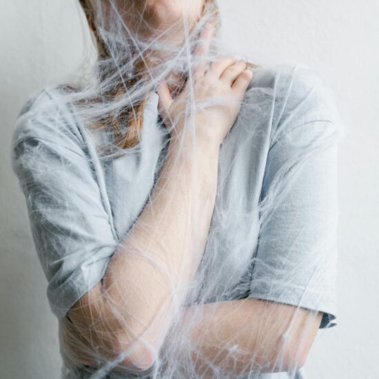 close up photo of a helpless woman trapped in a spider web